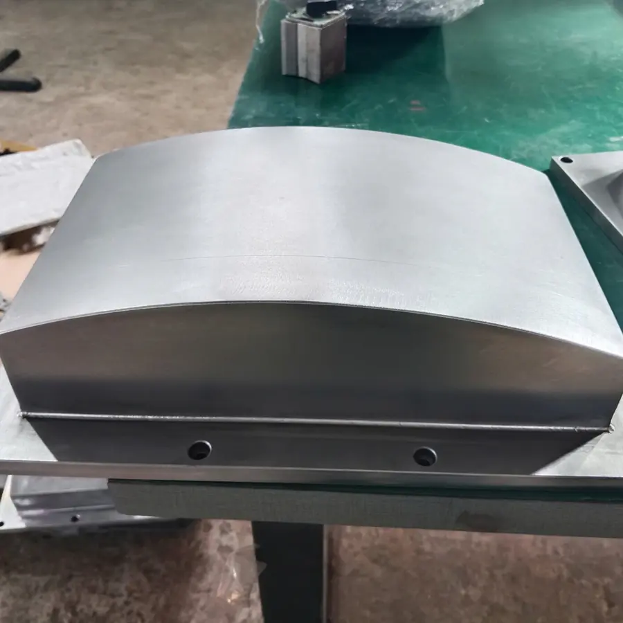 CNC machined housing with curved top on a flanged base plate with mounting holes