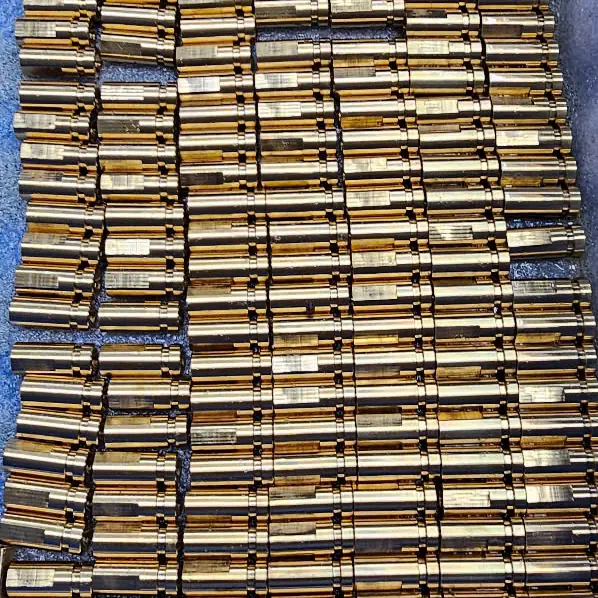 High volume batch of small CNC turned contact pins with gold plating laid in rows